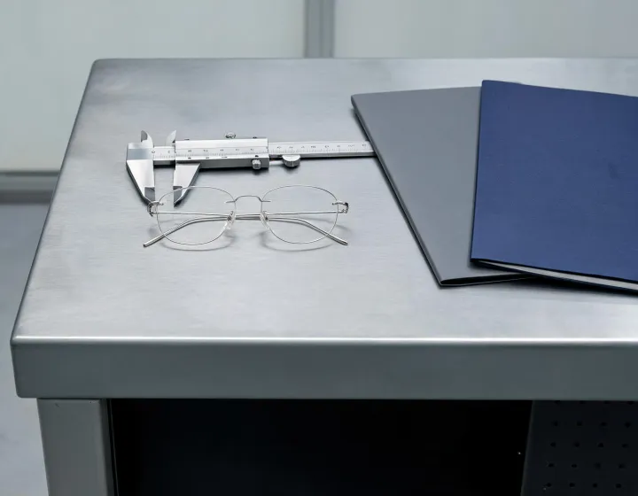 Rimless titanium glasses quote comparison sketch on an inspection bench